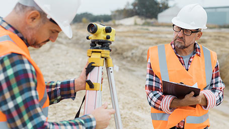 Land surveyor with glasses carefully notes details